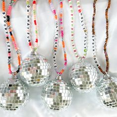 four disco ball ornaments hanging on a white background