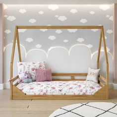 a bedroom with a canopy bed and white clouds painted on the wall behind it,