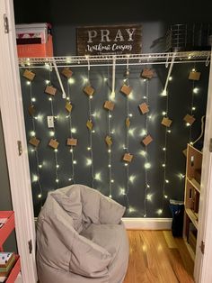 a room with a bean bag chair and string lights hanging from the wall behind it