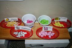 three red plates with different types of food in them on a table next to a white wall