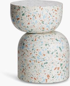 two small stools made out of cement with different colors and shapes on the top