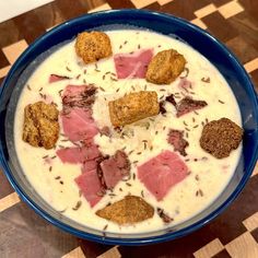 a blue bowl filled with food on top of a wooden table