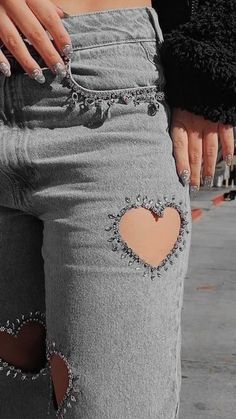 a woman wearing ripped jeans with a heart cut out on the side of her leg