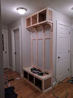 a room with some shelves and shoes on the floor next to a door that has been built into it