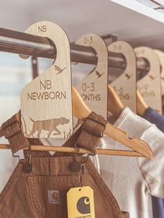 wooden clothes hangers with name tags on them in a clothing store or nursery shop