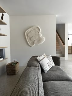 a living room filled with furniture and a large white heart shaped wall hanging on the wall