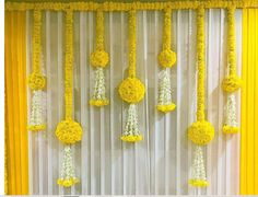 yellow and white decorations hanging from the side of a wall