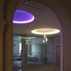 an arched doorway leading to a bathroom with lights on the ceiling