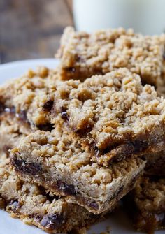 three oatmeal bars stacked on top of each other with a glass of milk in the background