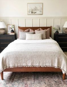 a bed with two nightstands and lamps in a room