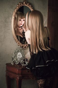 a woman is looking at herself in the mirror