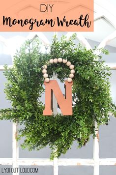 a diy monogram wreath hanging on a fence with the letter n in it