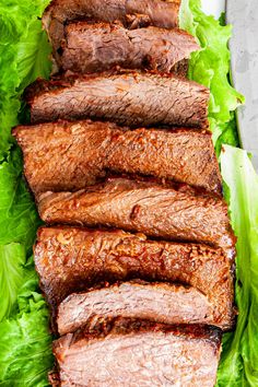 sliced flank steak with lettuce on a plate