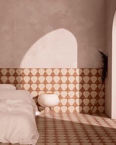 a white bed sitting in a bedroom next to a wall with geometric designs on it