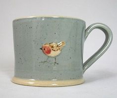 a ceramic mug with a small bird on it