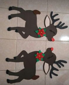 two reindeer cut outs sitting on top of a tiled floor