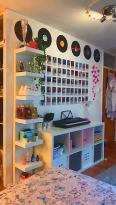 a bed room with a neatly made bed and lots of records on the wall