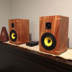 two wooden speakers sitting on top of a table