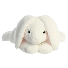 a white stuffed animal sitting on top of a white floor next to a white wall