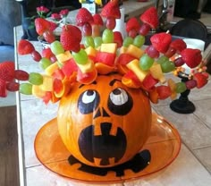 a carved pumpkin with fruit on it's head