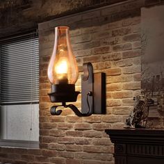 a light that is on the side of a brick wall next to a fire place