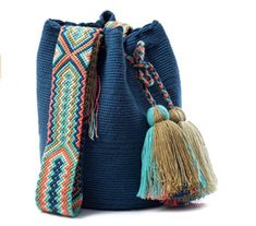 a blue bag with tassels on the side and a small purse in front