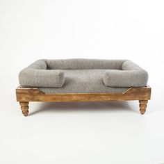 a dog bed made out of wood and fabric