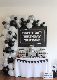 a star wars birthday party with black and white balloons, desserts, and decorations