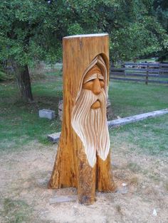 a wood carving of an old man with long white hair and beard on it's face