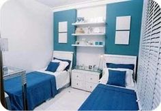 two beds in a room with blue and white decor on the walls, along with shelves