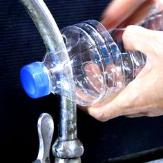 a hand holding a large plastic bottle filled with coins