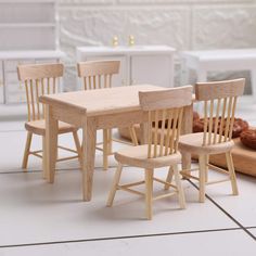 a wooden table and chairs sitting on top of a tile floor next to doughnuts