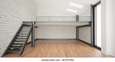 an empty room with stairs and brick wall