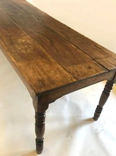 an old wooden table sitting on top of a white floor