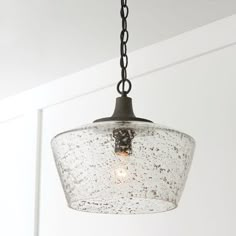 a light fixture hanging from a ceiling in a room with white walls and flooring