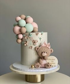 there is a cake decorated with balloons and a teddy bear