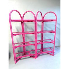 a pink shelf with two arched shelves on each side