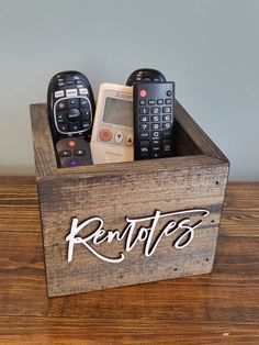 a wooden box with remotes in it on a table