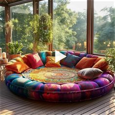 a large round couch sitting on top of a wooden floor next to a tall window