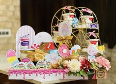 a table topped with lots of assorted candy and candies next to a ferris wheel