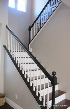 a white staircase with black handrails in a house