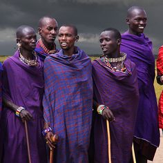 four african men in purple clothing standing together