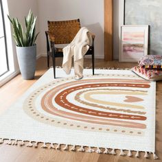 a living room area with a rug, chair and potted plant