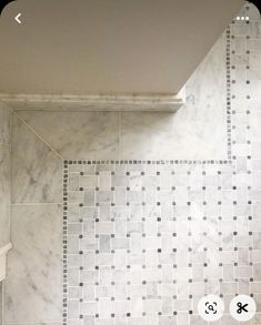 a bathroom with white and black tile on the walls