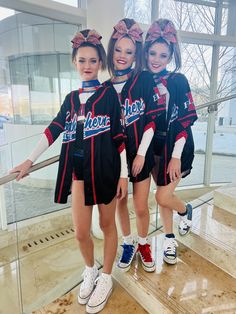 three girls in cheerleader outfits standing on steps