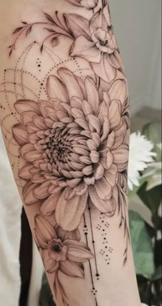 a black and white flower tattoo on the arm