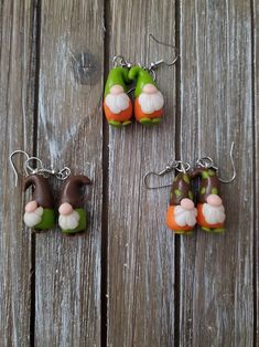 three different colored items are hanging from hooks on a wooden surface with wood planks