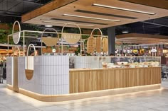 the inside of a restaurant with tables, chairs and food on display at the counter