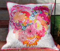 a colorful pillow sitting on top of a brick floor