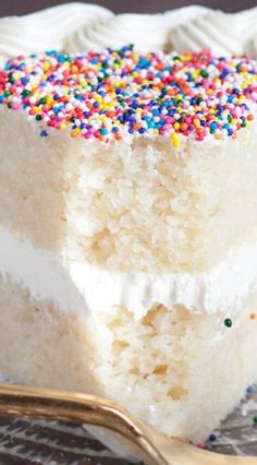 a slice of cake with sprinkles on it and a fork next to it